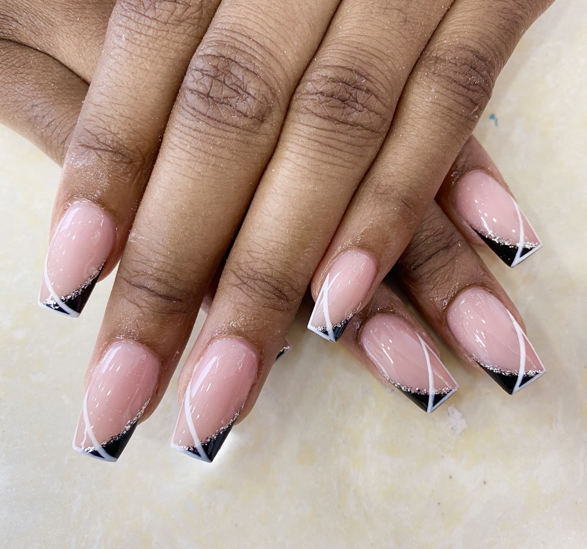 Long nails with a black French tip and rose-gold glitter line